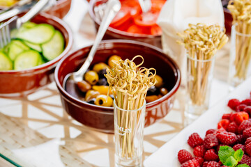 bowls with chopped vegetables and fruits on the table. 