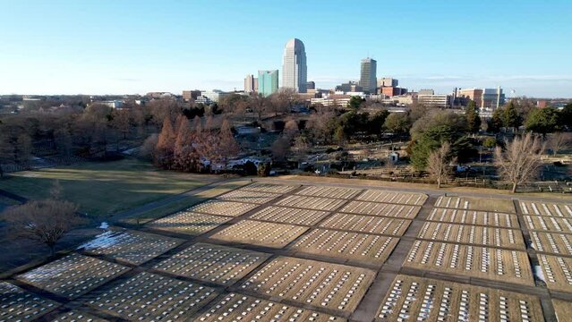 aerial push in to winston salem nc, north carolina skyline with god's acre near old salem in foreground