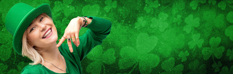 Banner with St. Patrick's Day leprechaun model girl on green magic background with shamrock leaves.