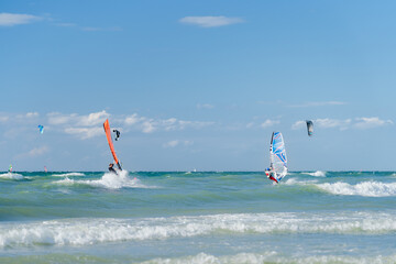 Surfer und Kiter auf der Ostsee in Warnemünde im Sommer bei Sonnenschein