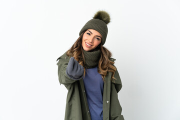 Young girl with winter hat isolated on white background making money gesture