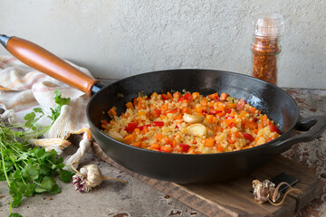 frying pan with couscous with vegetables on the table