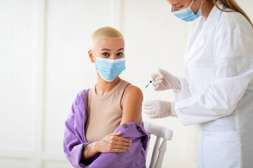 Get vaccinated. Millennial woman receiving coronavirus vaccination at clinic, promoting covid-19...