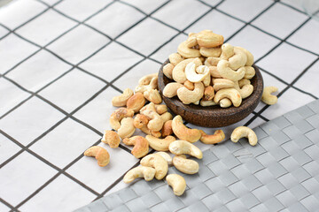 cashew nuts on a small wooden bowl with a checkered tablecloth