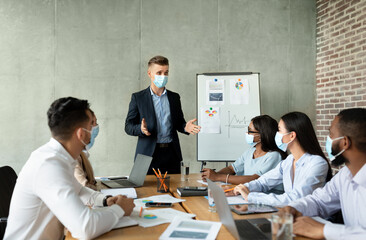 Pandemic Business Meeting. Businessman In Mask Having Conference With Coworkers In Office