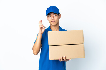 Delivery Chinese man isolated on white background with fingers crossing and wishing the best