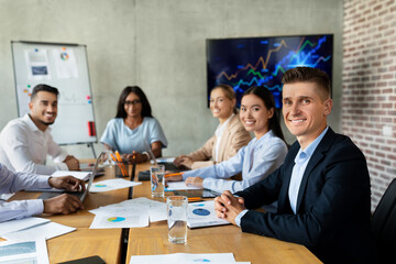 Modern Business Team. Group Of Multiethnic Colleagues Sitting At Desk In Office