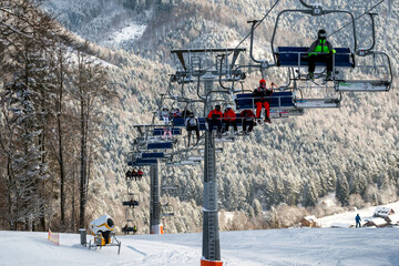 Skier sitting on ski-lift chair or chairlift