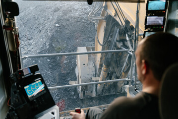View from the cab of a heavy excavator at a gold mining site.	