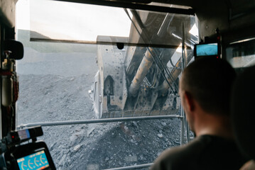 View from the cab of a heavy excavator at a gold mining site.