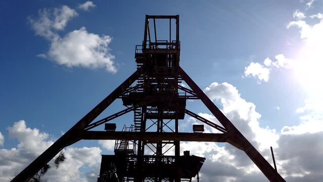 Timelapse looking up at the tower at the Mitsero mines against a beautiful blue cloud sky.