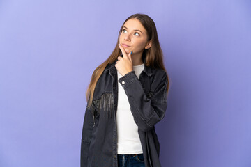 Young Lithuanian woman isolated on purple background looking up while smiling