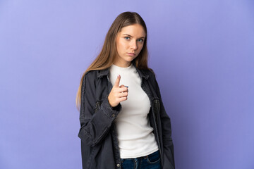 Young Lithuanian woman isolated on purple background frustrated and pointing to the front