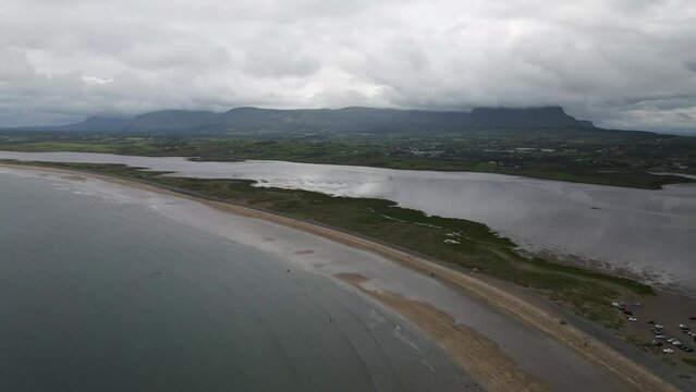 Drone shot of a beach with mountains in the background in Ireland.