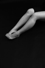 Beautiful female legs, feet and shin. Close-up of a limb on a dark background. Soft focus background, blurry and fuzzy defocused image with small noises.