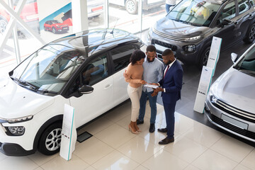 Buying Car. Auto Showroom Manager Consulting Young Black Spouses, Top View