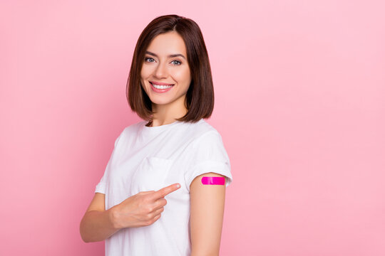 Photo of cheerful lady patient point finger patch on shoulder recommend advert inoculation isolated on pink color background