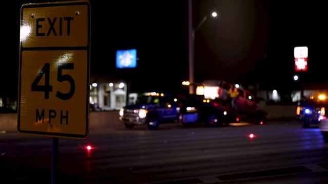 Police responding to crash site on interstate with car being towed, blurred background. Car accident in 45 mph reduced speed limit, state trooper and first responders on scene