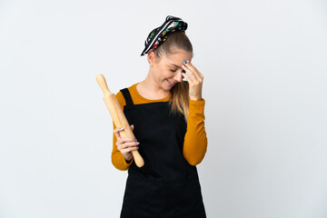 Young Lithuanian woman holding a rolling pin isolated on white background laughing