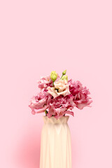 Bouquet of eustoma flowers in front of pink pastel background. Springtime concept with copyspace.