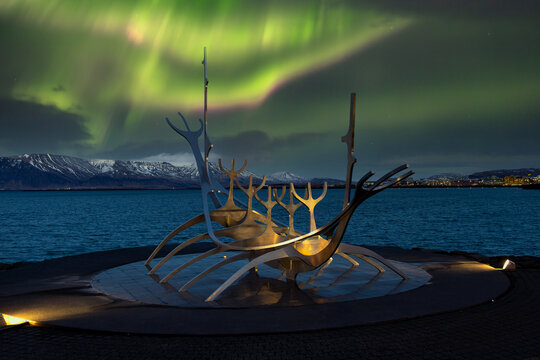Reykjavik. Iceland.22.12.2021. Metallic sculpture Sun Voyager in the Northern Lights. Aurora Borealis in downtown Reykjavik.
