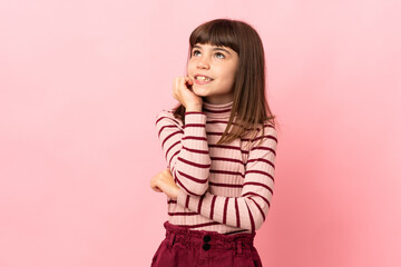 Little girl isolated on pink background is a little bit nervous