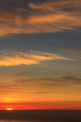 Yellow warm sunrise with sea clouds and ocean in the background. Vertical photo