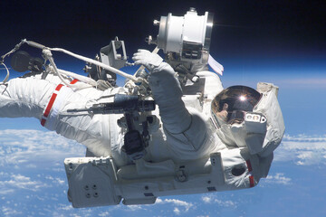 Astronaut in a spacesuit at the space station. Elements of this image were furnished by NASA