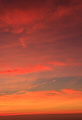 Red sunrise with clouds with sea in the background. Vertical photo