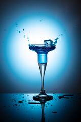 
cocktail blue lagoon in a wine glass on a blue background