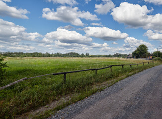 Fototapeta na wymiar Panoramic photo of a gravel road at rural Europe. Suburban road path