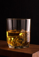 glass of cognac on a wooden brown table