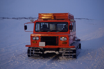 Red caterpillar all-terrain vehicle on a snowy road