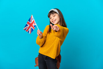 Little girl studying English isolated on blue background pointing front with happy expression