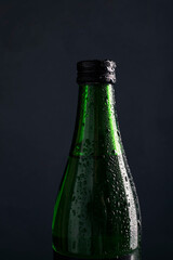 green bottle of water on a black background. green bottle of beer