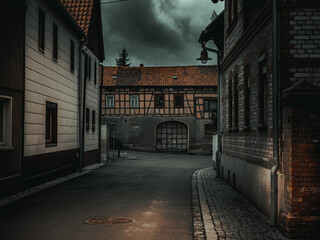Fototapeta na wymiar atmospheric Dark street of an old German city with thunderclouds