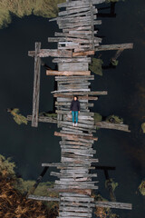 Aerial view of the Meditation by young women on the old wood bridge. Mellinial and hipster
