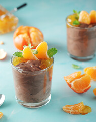 Chocolate mousse dessert with tangerines in glasses