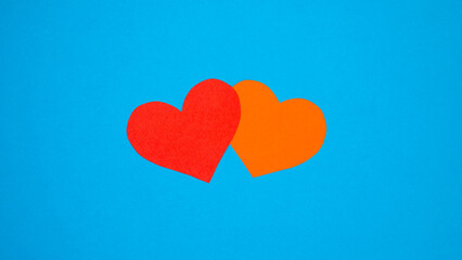 Fototapeta na wymiar Red and orange paper heart on a blue background. Copy space for advertising.