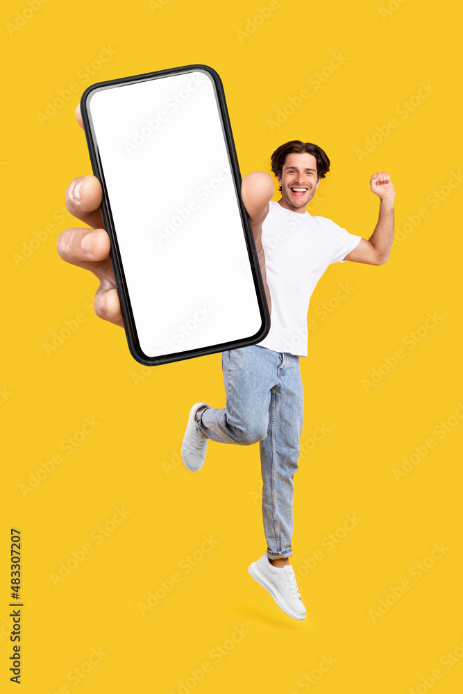 Aufkleber Man showing white empty smartphone screen and jumping up high