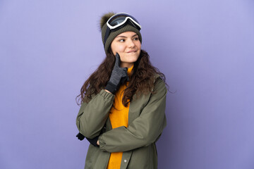 Teenager Russian girl with snowboarding glasses isolated on purple background thinking an idea while looking up