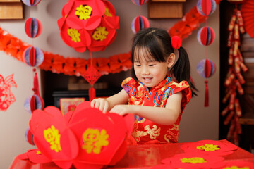 young Chinese girl making traditional Chinese "FU" means" lucky" Chinese lantern