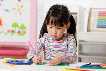 young girl drawing different shapes for home schooling