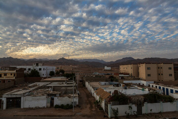 Local houses, beautiful cloud in the sky, mountains on the horizon during sunset. Dahab, Sinai peninsula, Egypt