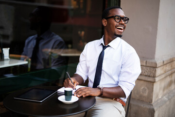 African businessman drinking coffee in cafe. Happy elegance man enjoy in fresh coffee.