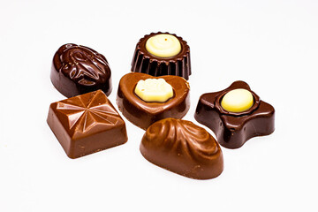 Pralines of various shapes and flavors on a white background