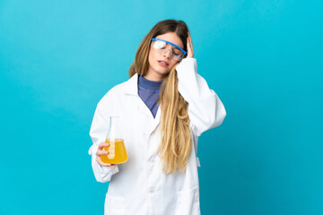 Young blonde scientific woman isolated on blue background with headache