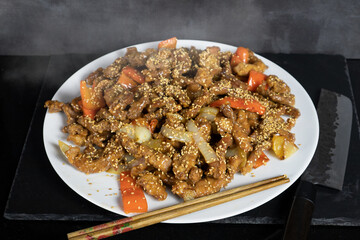 pork loin with sweet and sour sauce, asian recipe with chopsticks