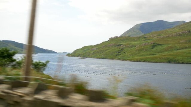 Driving through the Ireland countryside with beautiful green Lakes, Mountains and hills.