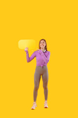 Photo of cheerful sport woman pointing at yellow blank speech bubble.